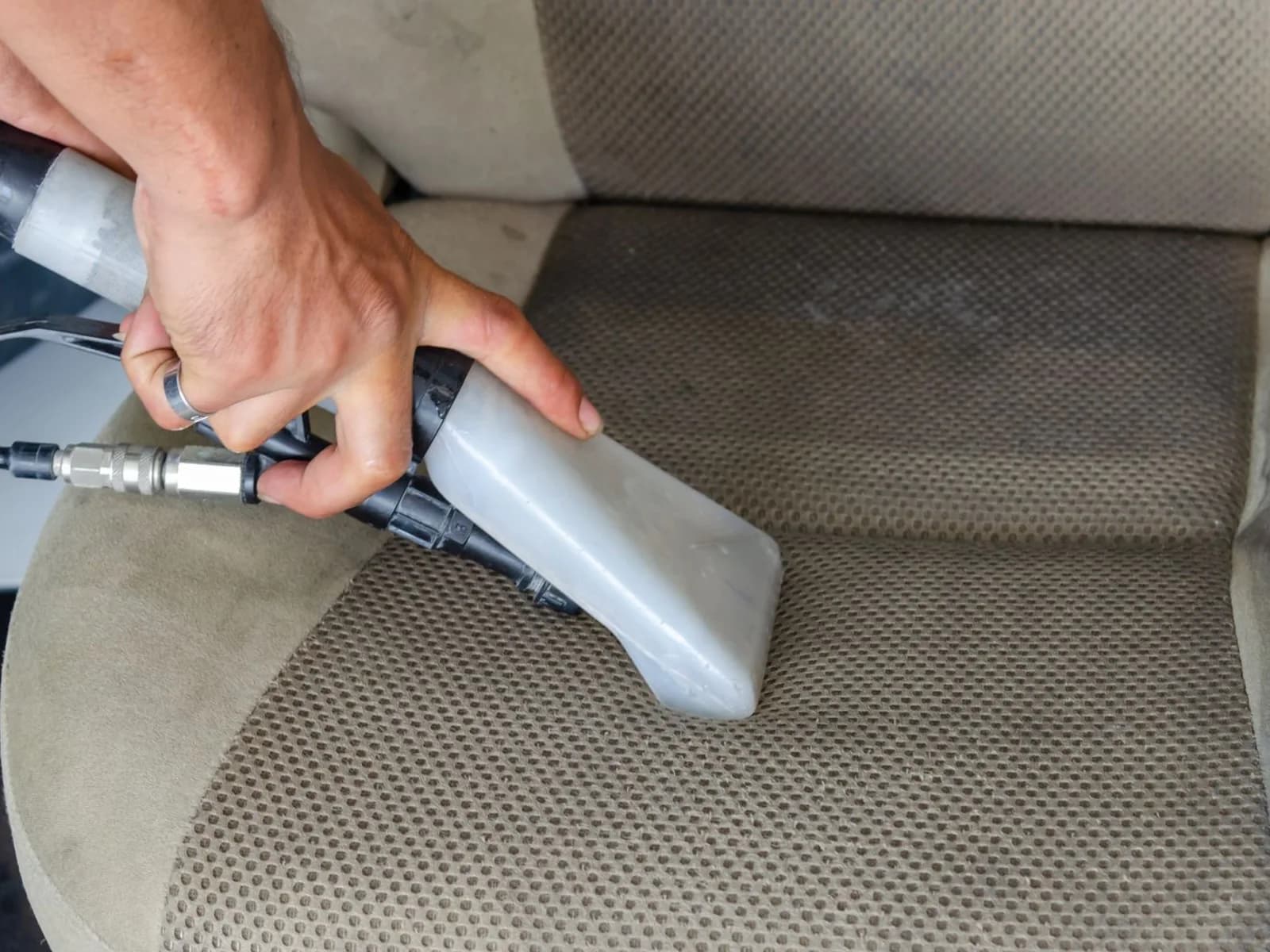 Limpieza profunda de asiento de tela de auto con aspiración dirigida