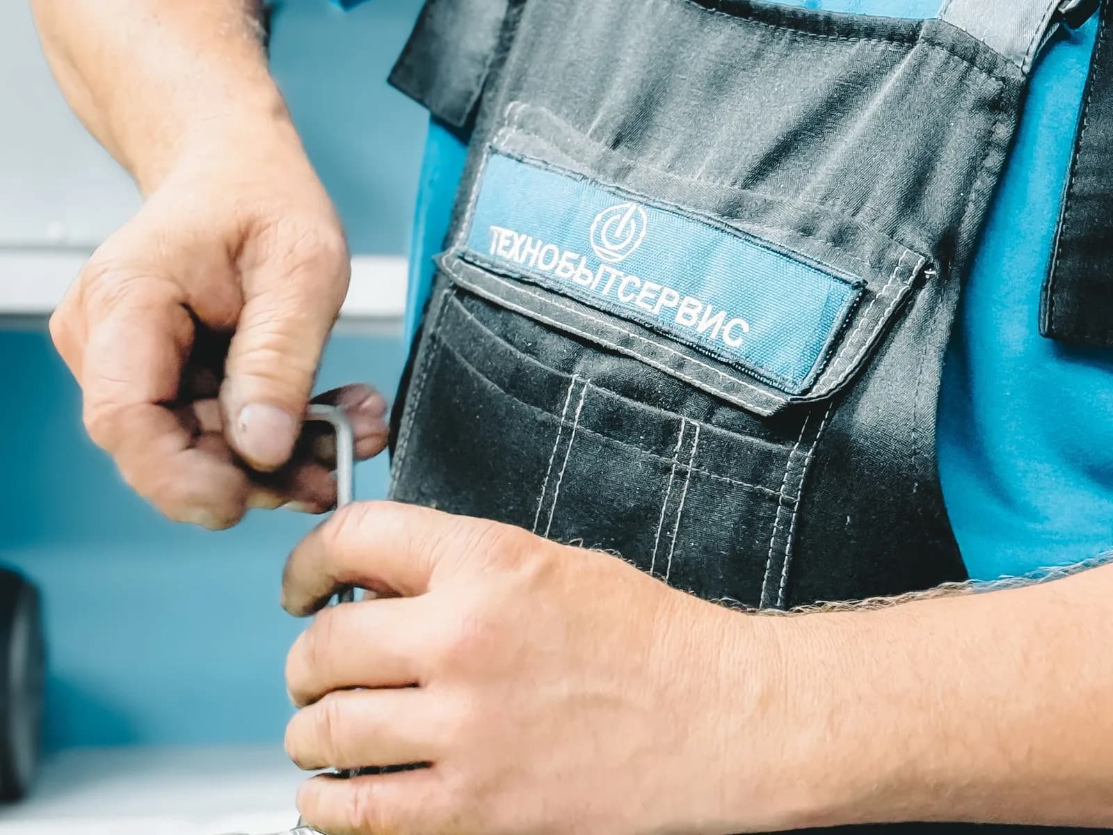 Técnico reparando una tubería con llave inglesa en interior
